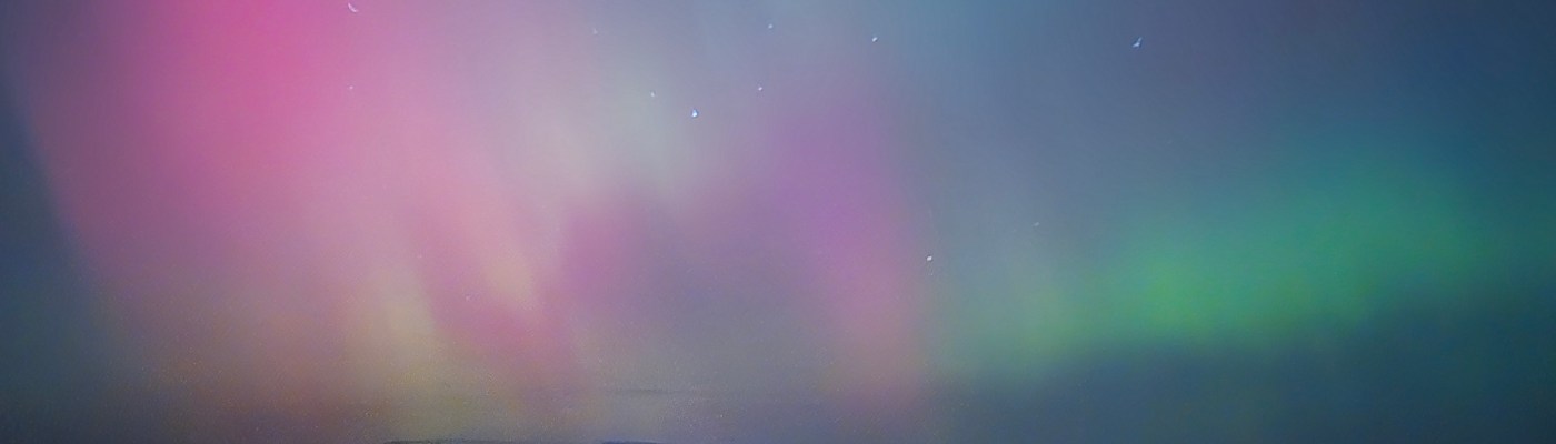 the northern lights, pink purple and blue above the northumberland hills